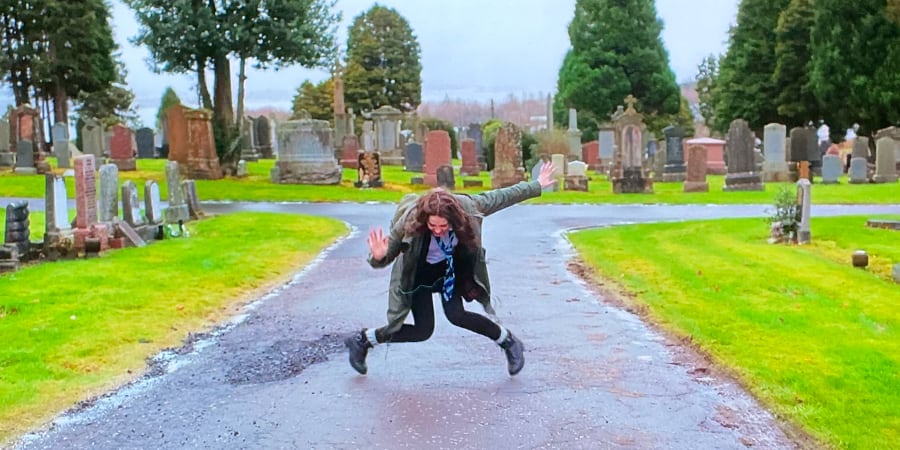 Anna dancing in a graveyard.