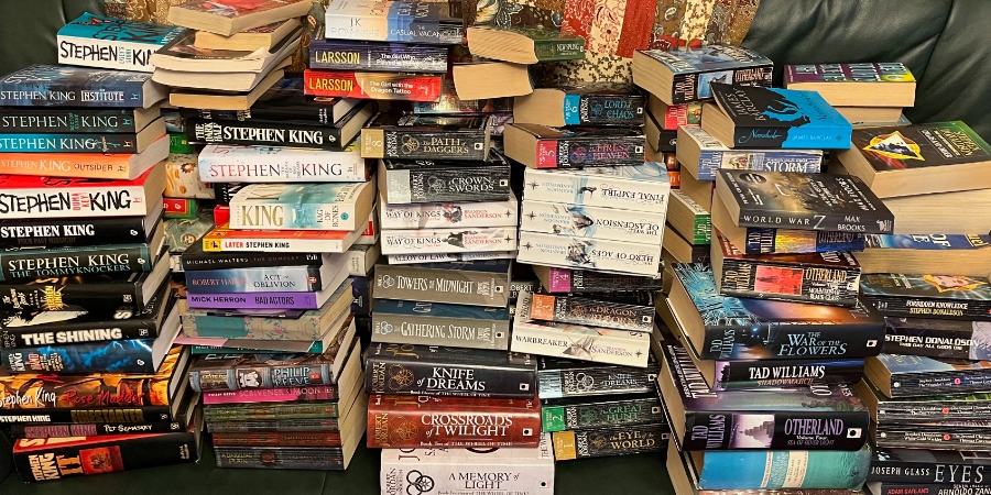 Piles of books on my father's sofa.